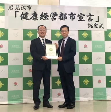 認定式の様子(左：岩見沢市長　松野 哲、右：健康経営研究会理事長　岡田 邦夫)2