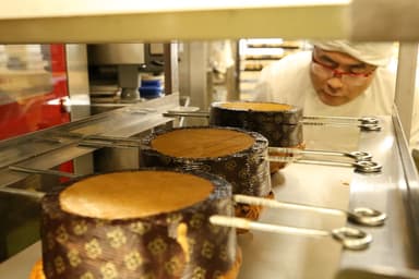 焼き上げたパネトーネを逆さに吊るす様子