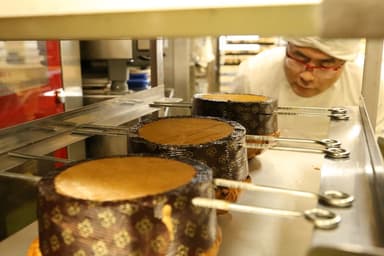 焼き上げたパネトーネを逆さに吊るす様子