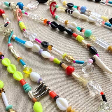 Cowries-talisman- タカラガイや珊瑚、シャンデリアのかけら、琥珀… 心ひかれたものを並列につないだ護符を模したプラスチック製の首飾りです。