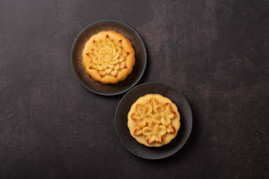 パイナップルとりんごの花の意匠が施されたムーンケーキ