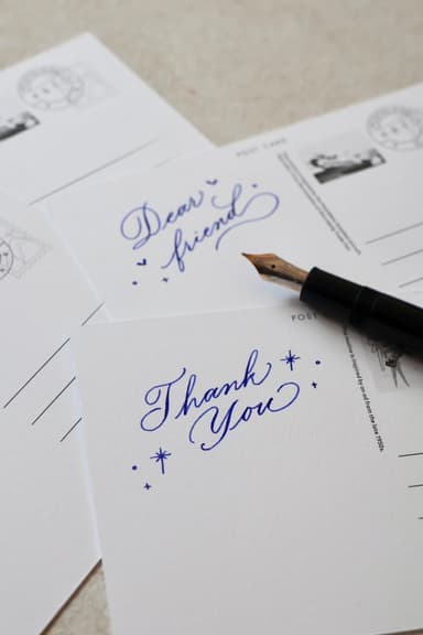 カリグラファーがポストカードに一言書き添えます