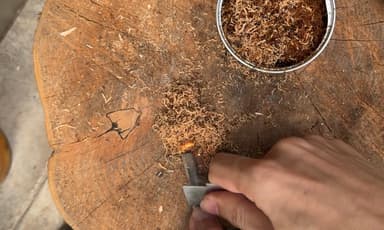 火口をメタルマッチで着火する様子