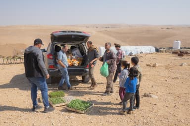 パレスチナ人家庭に食糧支援を届けるイスラエル人やパレスチナ人たち