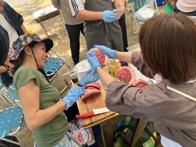 シュラスコ協会活動にて串打ちを教える姿
