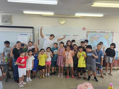 「日本語補修教室に通う子どもたちと笑顔で記念撮影する當間ローズ(湖西国際交流協会にて、2025年8月18日)」