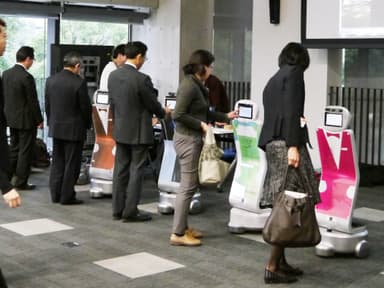 顔のタッチパネルを操作するアンケート デモンストレーションの様子