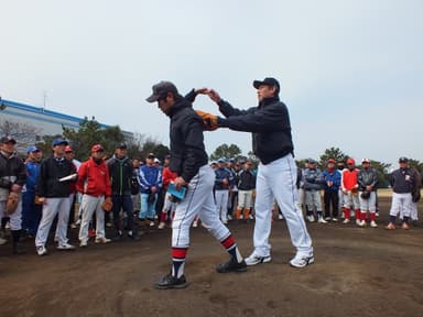 過去の野球教室のようす(投球時のフォームについて説明する西崎氏)