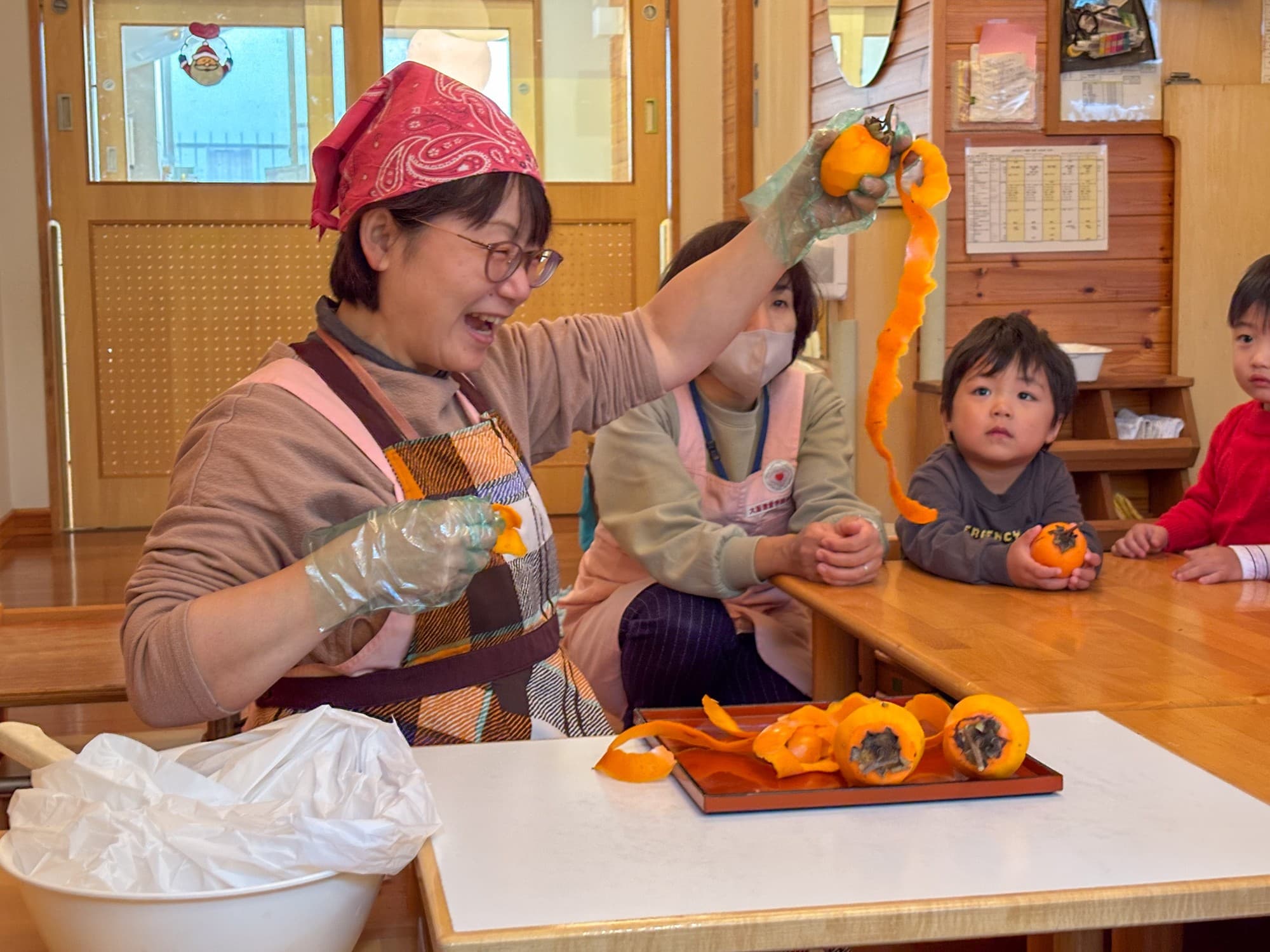 0・1・2歳から五感で学ぶ日本の食文化 大阪信愛学院幼稚園で毎年恒例の「干し柿作り」を実施
