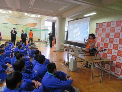 ドローン体験授業の様子（物流や航空写真・3Dモデルの作成といった、現場でのドローンの活用方法の説明）