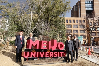 モニュメントで記念撮影する立花前理事長（右から２人目）ら