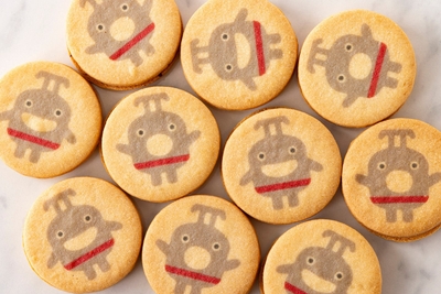 カカオ分の高いクーベルチュールを使ったチョコレートクリームをサクサクのサブレに可愛らしい表情の「のるるん」を乗せてサンドしました。　　東急電鉄株式会社商品化許諾済　ー東急線キャラクター のるるんー　