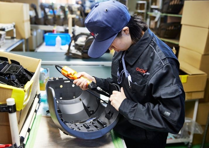 自転車用チャイルドシートを手作業で組み立てる様子