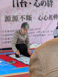 強風の中で集中して筆を走らせます