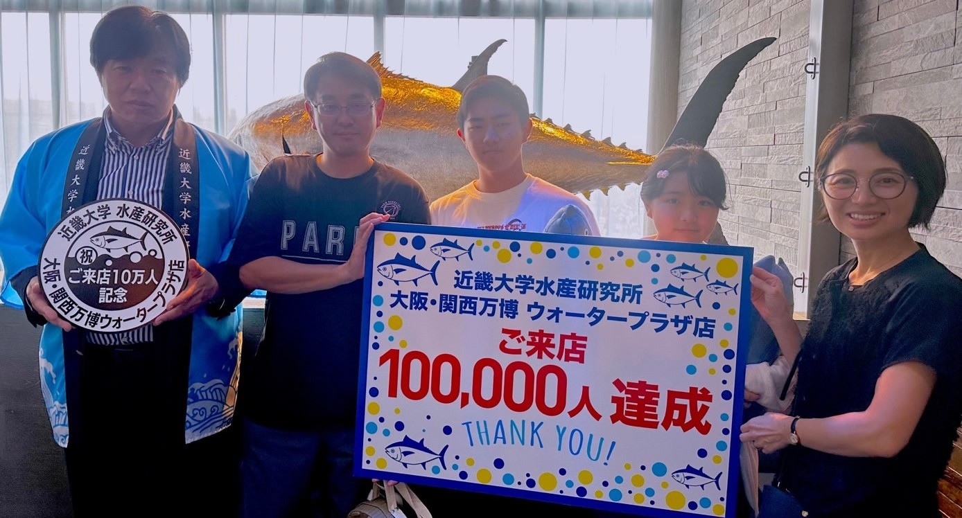 近畿大学水産研究所　大阪・関西万博ウォータープラザ店　来店者10万人達成セレモニーを開催　記念スタンプを設置