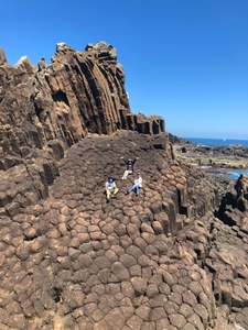 ジオ菓子を片手に現地を巡るツアーの一コマ