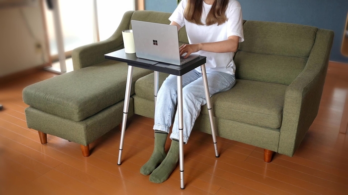 画像6　室内のソファに座りタイピングする女性