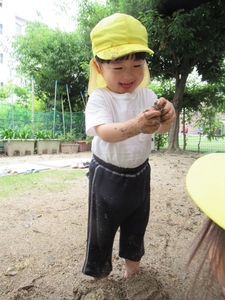 手や足で泥の感触を楽しむ園児