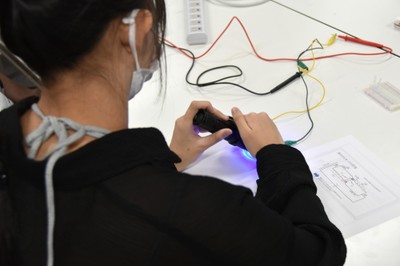 青色のLEDを照射して電気が流れることを測定する参加者
