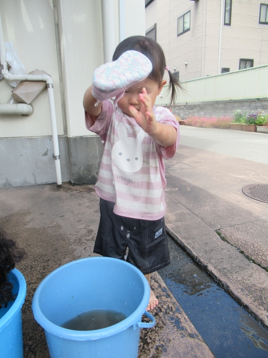 泥のついたサンダルを自分で洗う園児