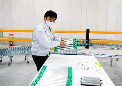 長さ1m、重さ5kg、コンパクトに収納できる同社独自開発の「丸まるコンベヤ」(MHE事業部MHE営業部東京MHEグループマネージャーの嶋津氏)