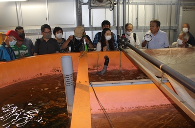 山本准教授（右から３人目）からウナギ養殖の説明を聞く受講者の皆さん