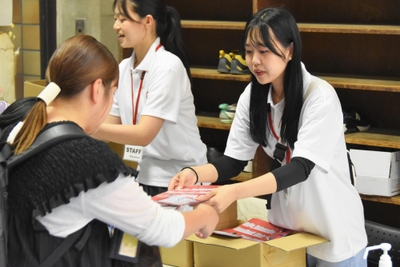 受付で応援グッズを渡すMSPのメンバー