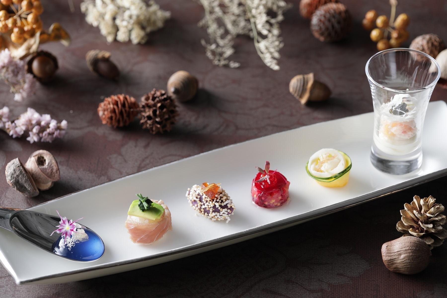 Hors-d’oeuvre】 〈ブルー〉甘みのあるマローブルーを酸味の効いたライムキャビアのはじける食感とともに 楽しめる一品。 〈グリーン〉春菊のほろ苦いソースがアクセントの一口大のお寿司。 〈パープル〉じっくり火入れした紫サツマイモにリンゴのカラメリゼとショウガのコンフィで 味わい豊かに仕上げました。 〈ルージュ〉サーモンのタルタルをローストビーツでサンドした見た目も鮮やかなジュエル風に 〈オレンジ〉甘みのあるアオリイカと白ワインでマリネしたサキイカを添えた季節野菜の 鈴かぼちゃと蓮根のサラダ仕立てで食感を楽しめます。 〈ホワイト〉イタリアの魚醤コラトゥーラがアクセントのズワイガニとカリフラワーのムース、ブーケのようにスライスしたカリフラワーを添えて華やかに。