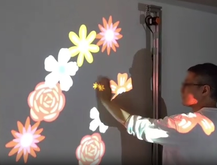 測域センサーによるデモの様子。手の動きに合わせて花が咲く