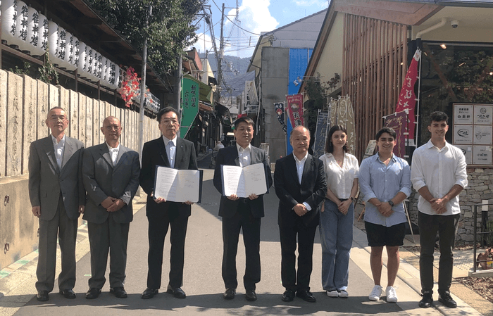 印式での記念撮影の様子(左から、石切参道商店街振興組合石切参道プロジェクトチームリーダー 布一正、同 岩瀬伸一、近畿大学社会連携推進センター長 伊藤哲夫、石切参道商店街振興組合理事長 中澄史雄、近畿大学副学長 渥美寿雄、近畿大学留学生3名)