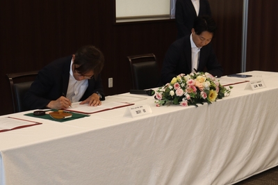 協定書に署名する（左から）加計理事長、山本社長