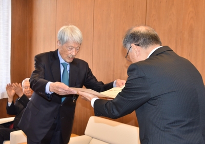 野口学長（右）から名誉学位記を手渡される長谷川顧問