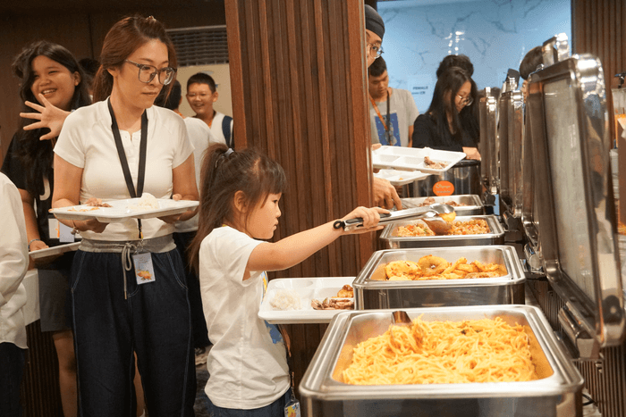 留学生がブッフェ形式の食事をとる様子