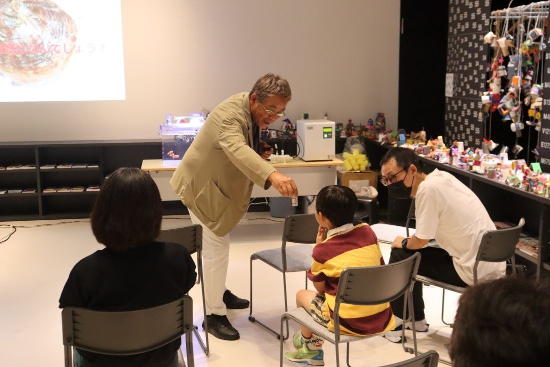 参加者に陸上養殖真珠を披露する山本准教授