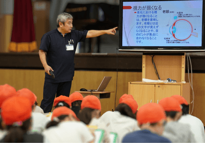 福祉学習の導入で、高齢者の身体の変化について説明する職員