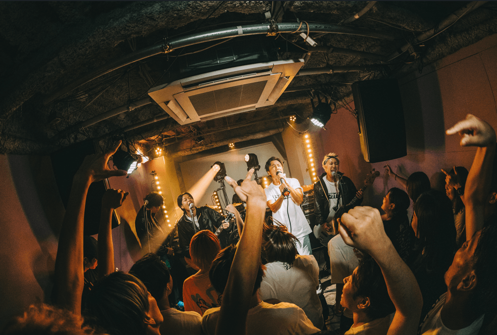 沸き上がるライブ会場と、ステージ上の原田さん & POTのメンバー