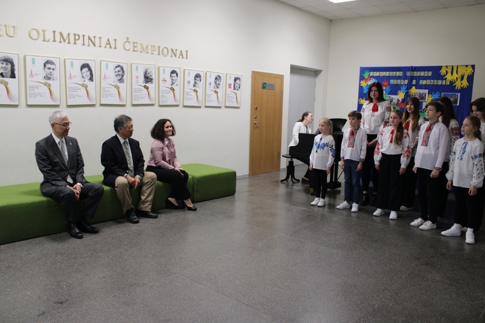 子どもたちの歌を聴く(左から)尾崎大使、稲葉教授