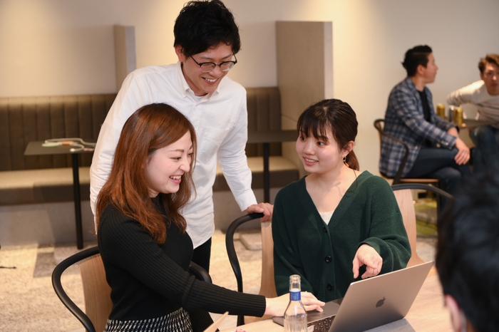 インターン生が社員にアドバイスをもらっています