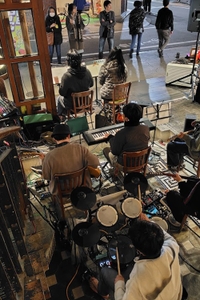 店頭の水盤ステージにメンバーが並び、栄通りを行き交う人々が足を止めて耳を傾ける7days1dayのサプライズフリーライブ