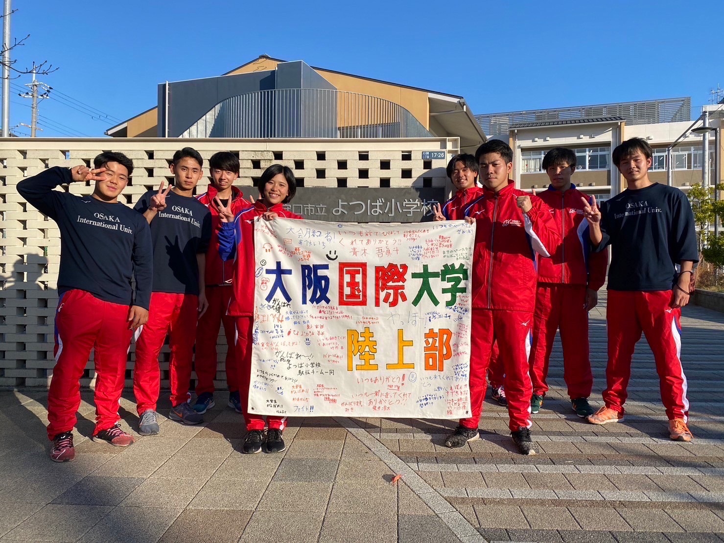 大学駅伝出場にあたり、児童から応援メッセージを寄せ書きした旗をいただく(よつば小学校前にて)