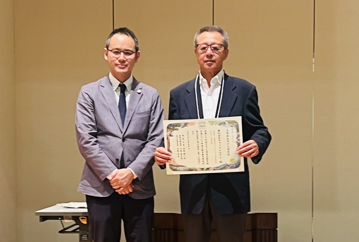自然共生サイトの認定証を手にする成田社長(右)