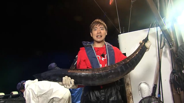 魚を持ち上げる辻本達規(BOYS AND MEN)