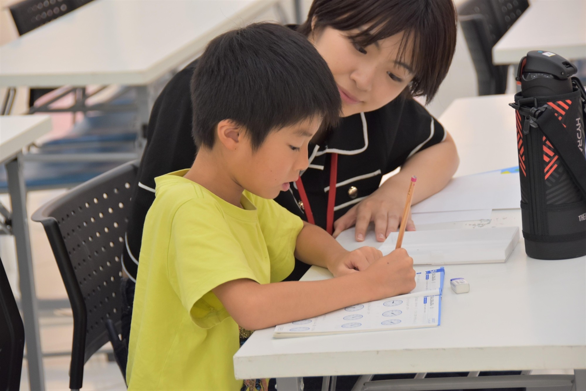 真剣に宿題に取り組む子供たちを学生たちが優しくサポート