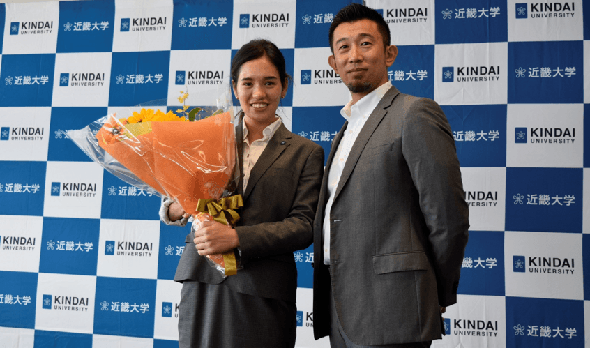 会見での花束贈呈 一ノ瀬 メイ(左)、近畿大学水上競技部監督 山本 貴司(右)