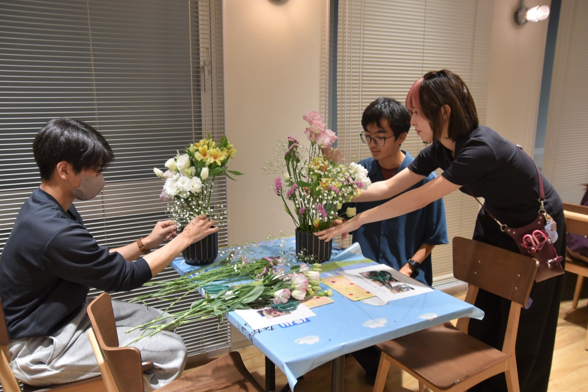 名古屋ウエディング&フラワー・ビューティ学院の学生からアドバイスを受ける男子学生