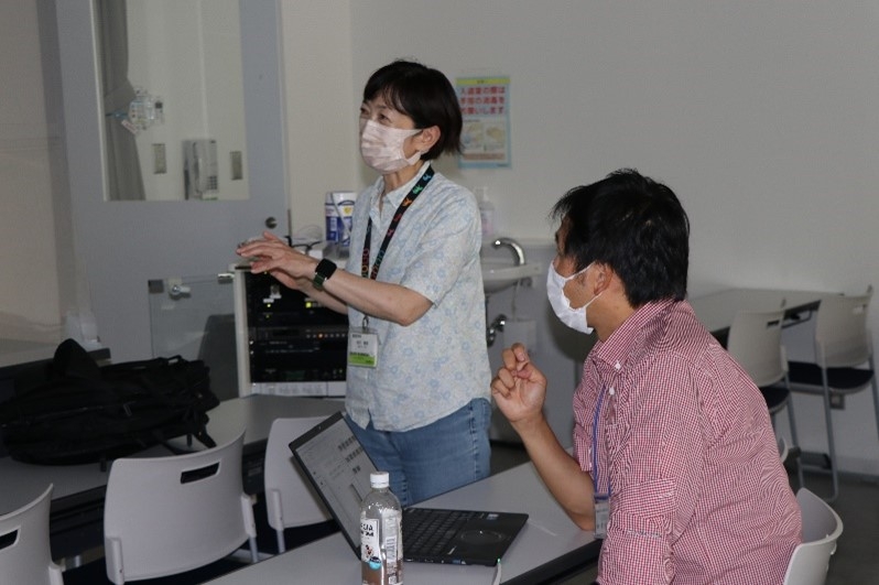 李教授(右)から動画の自動追跡ツールの説明を受ける岩田教授(左)