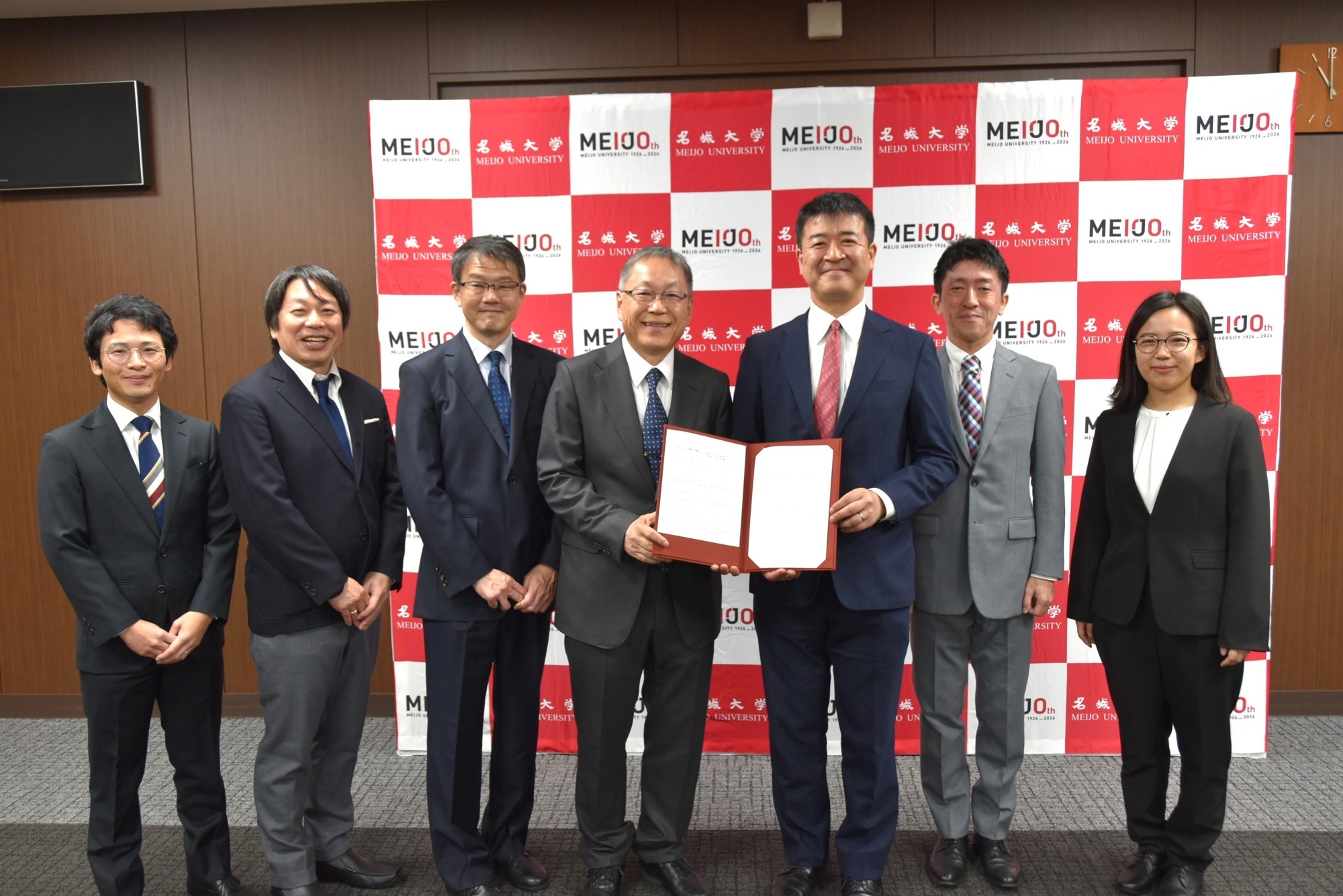 関係者の記念撮影。左から外国語学部の宮下准教授、増田教授、冨岡学部長、野口学長、JICA中部センターの上町所長、市民参加協力課の山本課長、五十嵐氏