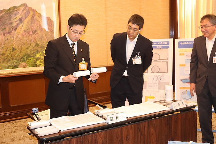 粘着テープのクリーナーで従来品との毛の残留具合を比べる菅副知事(左)