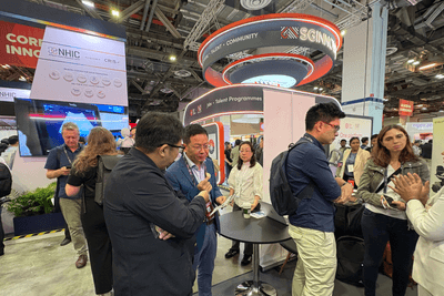 ブースを訪れた人に説明するトイメディカル株式会社代表取締役社長 竹下英徳（左）