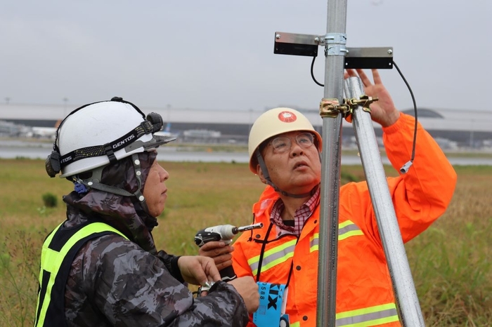 スピーカーの向きを調整する辻特坦教授(右)と轟社長(左)